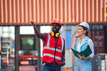 Obraz premium Businesswoman and engineer talking and checking loading Containers box from Cargo freight ship for import export. shipping in docks.
