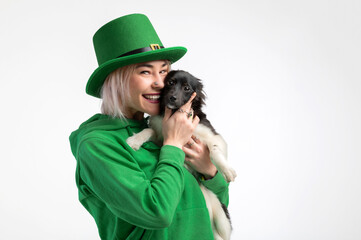 St. Patrick's Day. Beautiful smiling woman wearing green hat with dog.