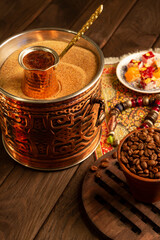 Traditional Turkish coffee in cezve on the sand.