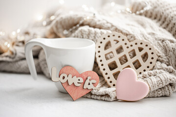 Cozy composition for Valentine's Day with a cup and decor details.