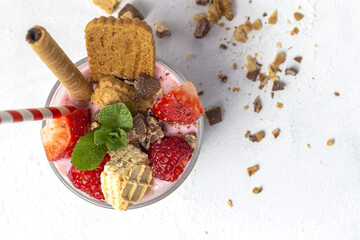 Homemade Yogurt with red berries, cookies and chocolate on white wooden table