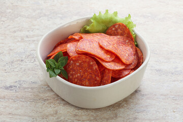 Sliced pepperoni sausage in the bowl