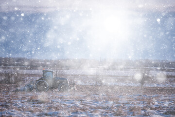 tractor in the field arable land winter agribusiness landscape seasonal work in a snowy field