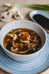 Homemade asian spicy soup style with soy sauce and mushrooms champignons and big prawn