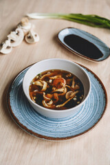 Homemade asian spicy soup style with soy sauce and mushrooms champignons and big prawn