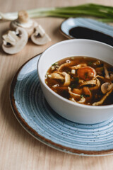 Homemade asian spicy soup style with soy sauce and mushrooms champignons and big prawn