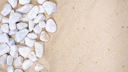 Fototapeta na wymiar Decorative small white stone pebbles on the sand. Background, texture, copyspace