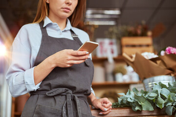 Busy florist photographing freshly made bouquet for social media