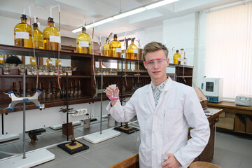 Fototapeta na wymiar A young scientist with a test tube. Chemical experiments in the laboratory. Chemistry.