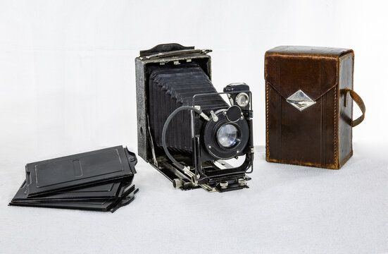 Vintage camera  made in the USSR in 1935 with cassettes and a brown leather case on a white background
