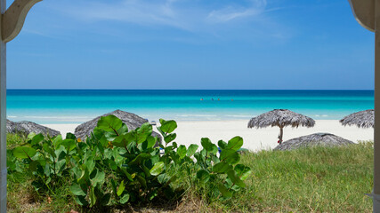 Wonderful white sandy beach, tropical plant, wooden parasol and Caribbean sea, Varadero at sunny day ,Cuba