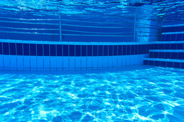 Fototapeta na wymiar Underwater part of the pool with tiles and reflections on the bottom