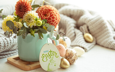 Easter composition with a bouquet of flowers and eggs on a blurred background.