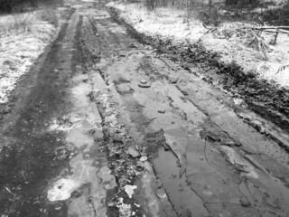 Frozen puddles on a dirt road. Nature in winter