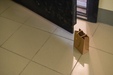 An eco paper bag is standing in the lobby on the doorstep of the apartment. Contactless food delivery to the epidemic. The courier left an online order at the entrance. precautionary measures.