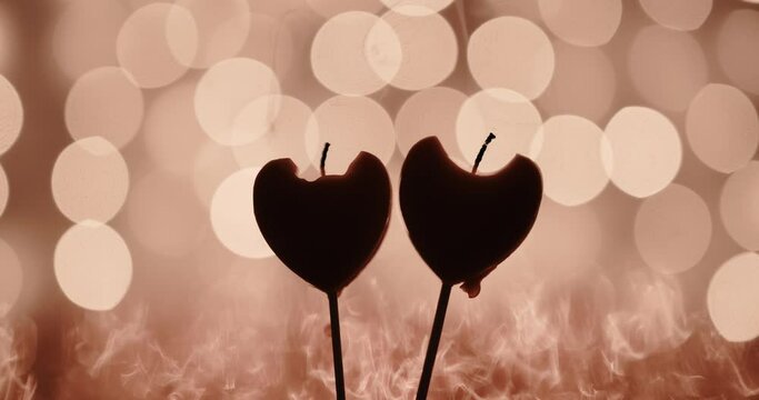 burning candles in the form of hearts on a background of beautiful bokeh. the concept of the passion of love and strong emotions of feelings and experiences. background for valentine's day