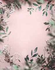 Beautiful frame of green leaves at pink pale background with copy space. Nature background. Top view.