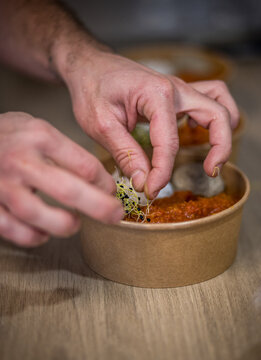 Pr&eacute;paration d'un plat &agrave; emporter, rougaille saucisse avec son riz, dans un plat en carton