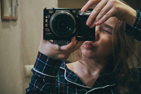 Teenage girl in pajamas, photographs herself in the mirror, film photography effect, grain film