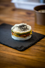 Préparation d'un burger sushi, riz et saumon. Préparation du plat sur une ardoise