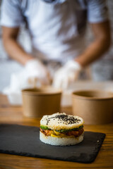 Préparation d'un burger sushi, riz et saumon. Préparation du plat sur une ardoise