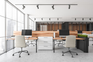 Bright office room interior with desktops, desks, armchairs, panoramic windows