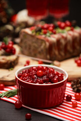 Cranberry sauce with Traditional French terrine on dark wooden background with Christmas decorations