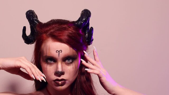 Evil woman with makeup zodiac signs of Capricorn or Aries or Taurus. Girl with horns on head.
