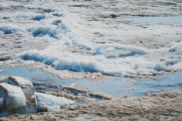 Spring ice drift on the Amur River. The movement of fragments of ice floes on a sunny day.