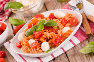 Fusilli pasta with cherry tomatoes and mozzarella cheese.