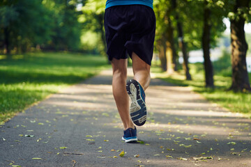 Rear view of a man running in a park on a summer sunny day