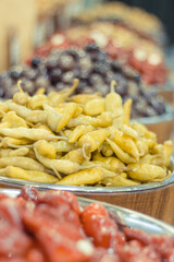 Fresh green marinated peppers in barrels on street market. Healthy snack containing vitamins