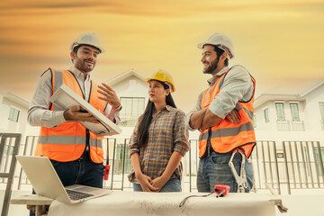 male engineer in a uniform and a female worker and a male Foreman in a safety helmet discuss the installation of solar cells for renewable energy. 