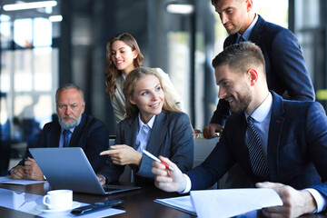 Group of business partners discussing ideas and planning work in office.