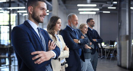 Obraz premium Happy smiling business team standing in a row at office.