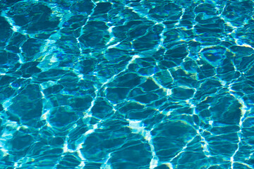 Ripple Water in swimming pool with sun reflection. Wavy water background.