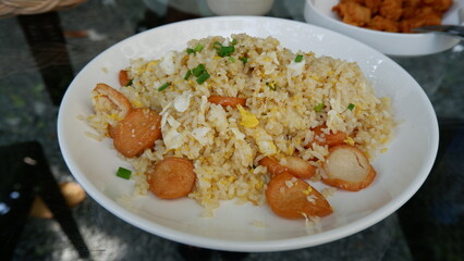 The top view of a dish of sausage fried rice on the grass table