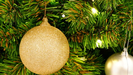 Close up of a gold ball decorated on the Christmas tree with the blink light