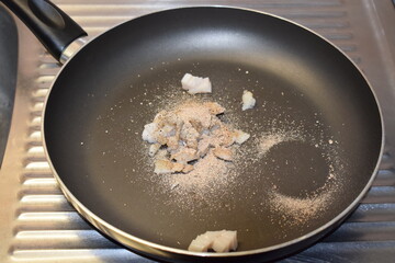Speck mit Gewürzen in der Pfanne