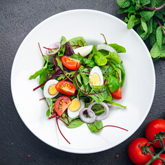 easter salad quail egg holiday snack tomato, lettuce mix leaves healthy meal food on the table copy space food background rustic top view 