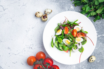 easter salad quail egg holiday snack tomato, lettuce mix leaves healthy meal food on the table copy space food background rustic top view 