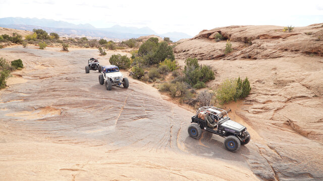 4x4 offroad jeeps driving in the desert sand landscapes of the Moab Sand flats in Utah, USA.