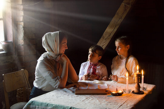 Poor Family At The Table. Mother Gave The Children The Last Piece Of Bread