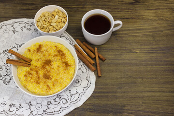 Corn porridge with peanuts and cinnamon in a round bowl