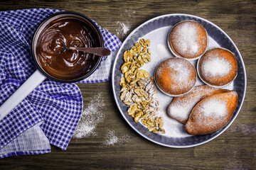 Delicious buns and walnuts in powdered sugar. Hot chocolate cooked in a saucepan.