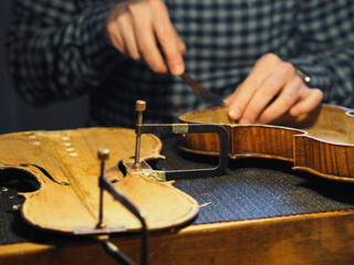 luthier artisan restoring an old italian classic handmade violin in his workshop - specialized craftmanship concept