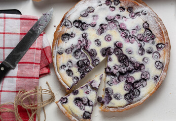 blueberry pie sprinkled with powdered sugar, knife and a napkin. the concept of the holiday is a...