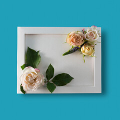 Pure white frame with white and pink bush roses on a blue textured background.