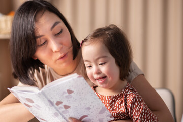 cute baby girl with down syndrome with book studying