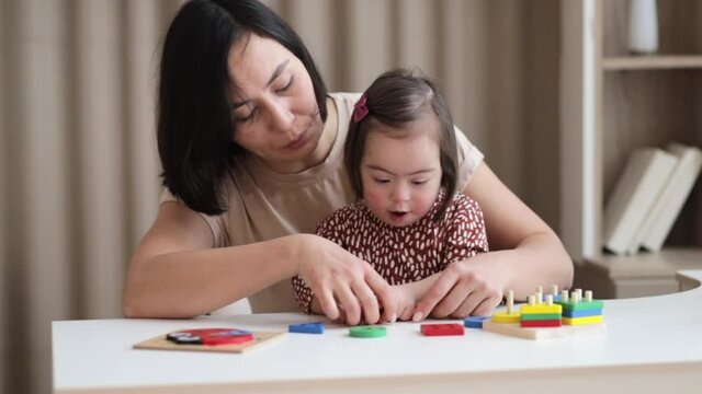 International Down Syndrome Day, March 21, care for the health and learning of children, a cute girl is engaged in the classroom, the inclusion of a special child